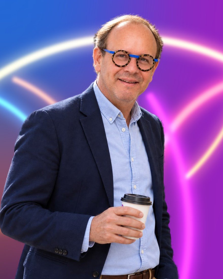 Thierry Garot, un café à la main, sur fond lumineux